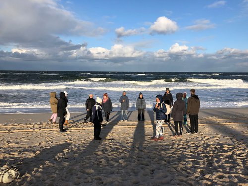 Yogagruppe unterwegs am Meer
